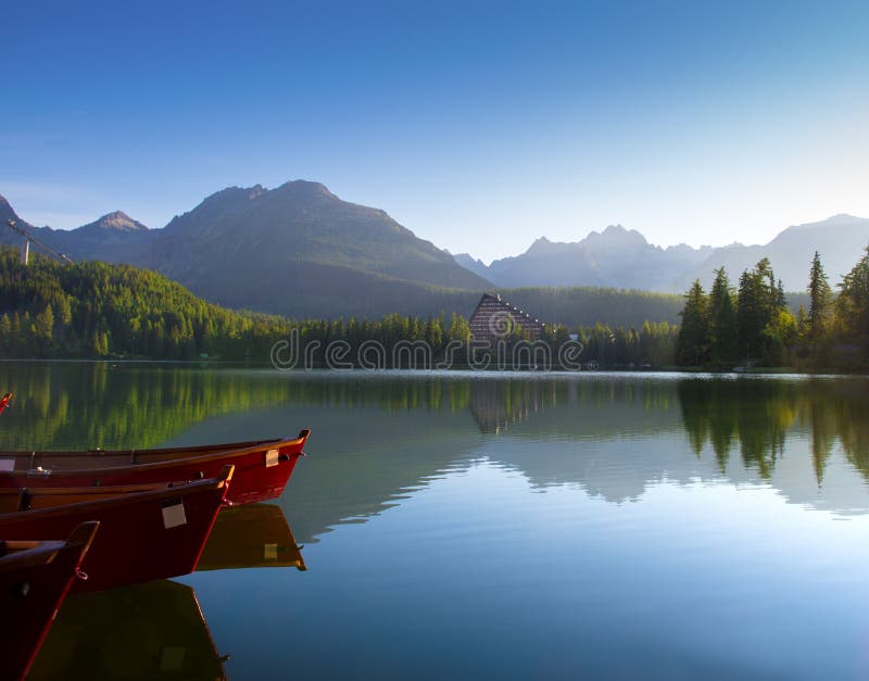Red boats in mountain lake in High Tatra. Strbske pleso, Slovakia, Europe