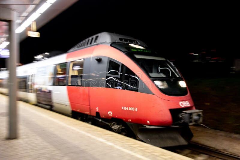 Red bombardier talentos 4124 0052 tren de obb austrian compañía conduciendo a lo largo de la plataforma en la estación de tren de fotos de archivo