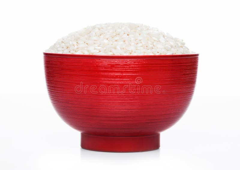 Red bowl of raw organic arborio risotto rice on white background. Healthy food stock image Red bowl of raw organic arborio risotto rice on white background. Healthy food stock image