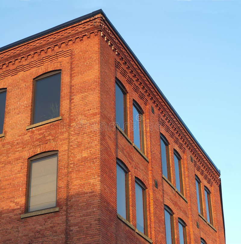 Red brick office building corner in sunlight blue sky