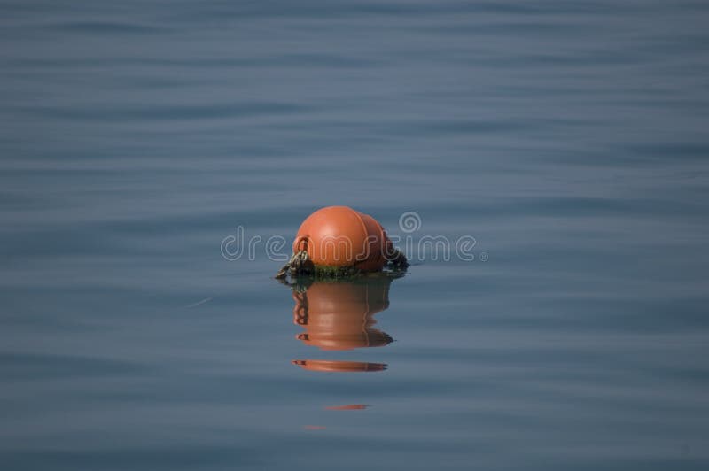 Red buoy beacon on a blue sea