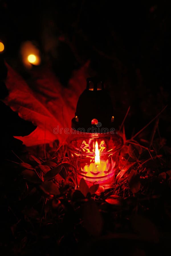 Red Burning Candle at the Cemetery on All Saints` Day Stock Photo