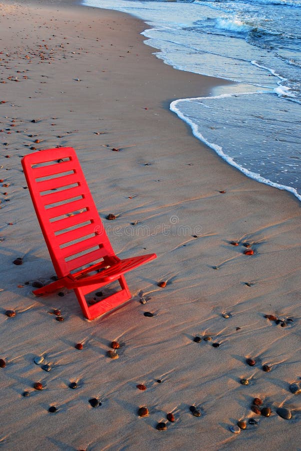 Red chair on the shore