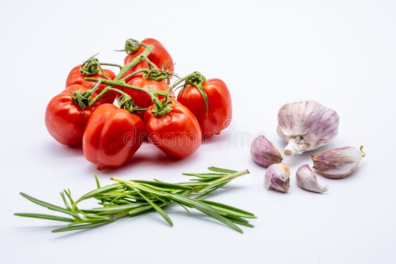Red Cherry Tomatoes with Garlic Cloves and Rosemary on White Stock
