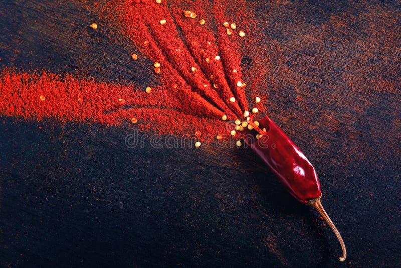 Red Chili Pepper Flakes and Chili Powder Burst on Black Background