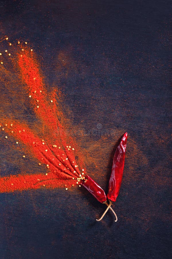 Red Chili Pepper Flakes and Chili Powder Burst on Black Background