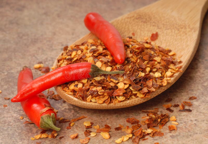 Red chili peppers and red pepper flakes on a spoon