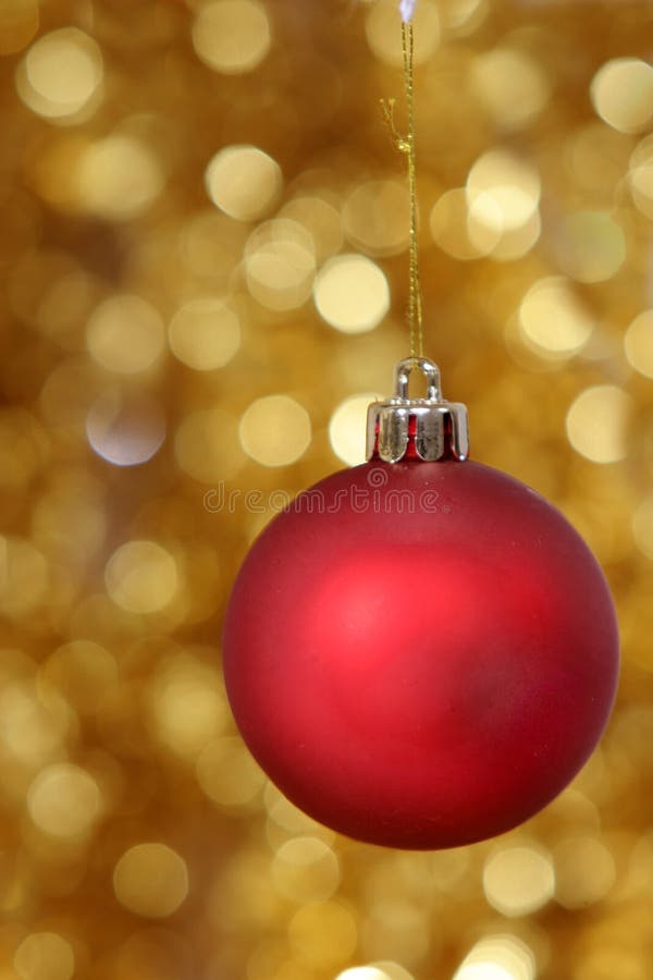 Red christmas ball against golden background