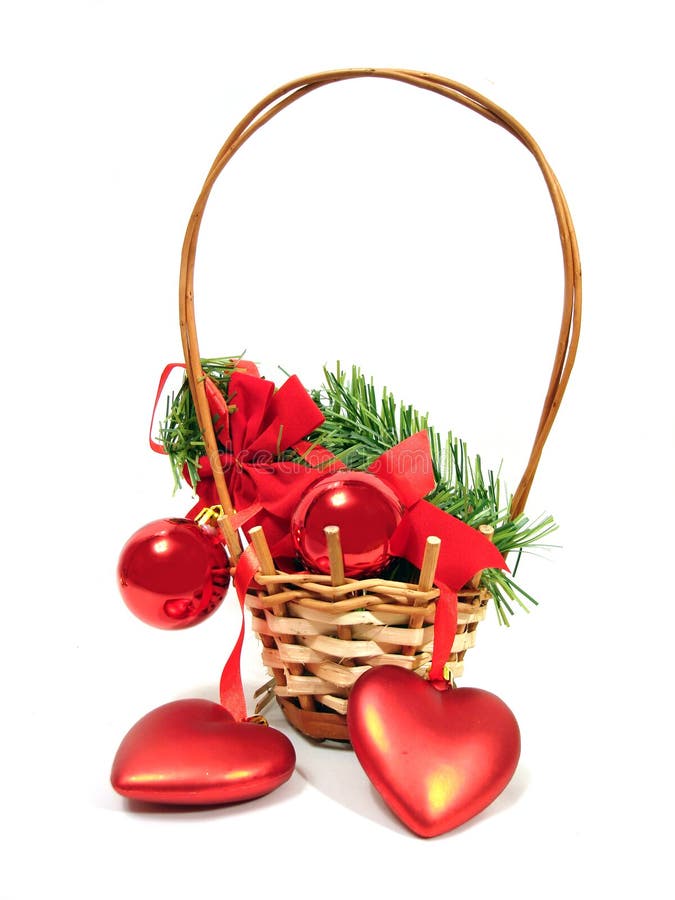 Red Christmas balls and hearts on a fur-trees branch in basket o