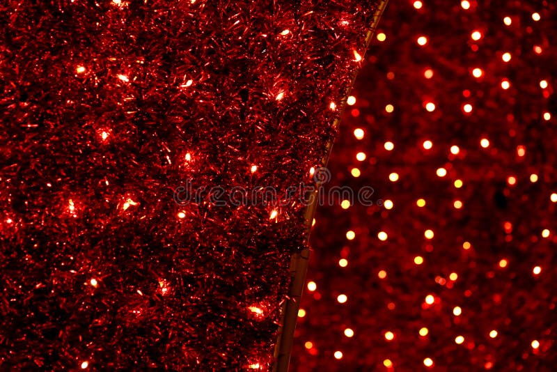 Red Christmas festive decorative background with tinsel, flashing lights. Wall illuminated by Christmas string rice lights bulbs. stock photo