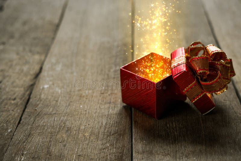 Red Christmas gift box with gold magic lights on wooden desk. Box christmas open stock images, royalty-free photos and pictures