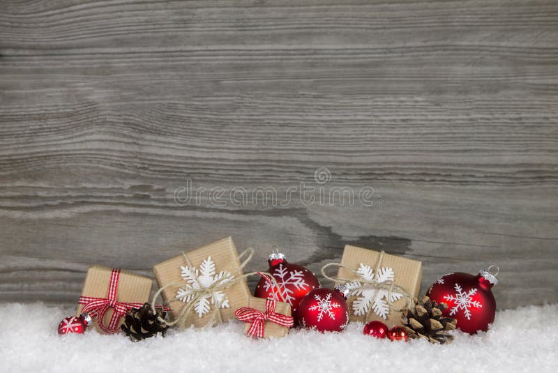 Red Christmas presents wrapped in natural paper on old wooden gr