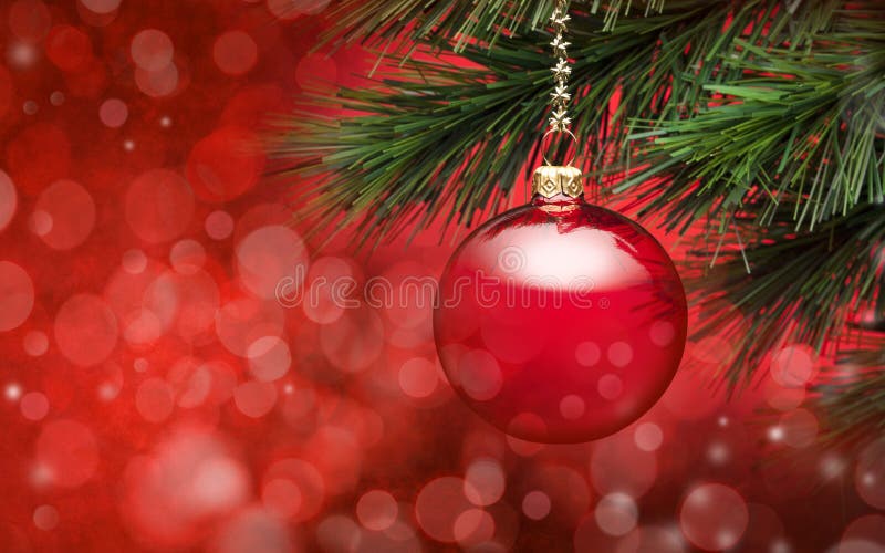 Červená vianočné ozdoby visí zo stromu s červeným osvetlením a bokeh v pozadí.