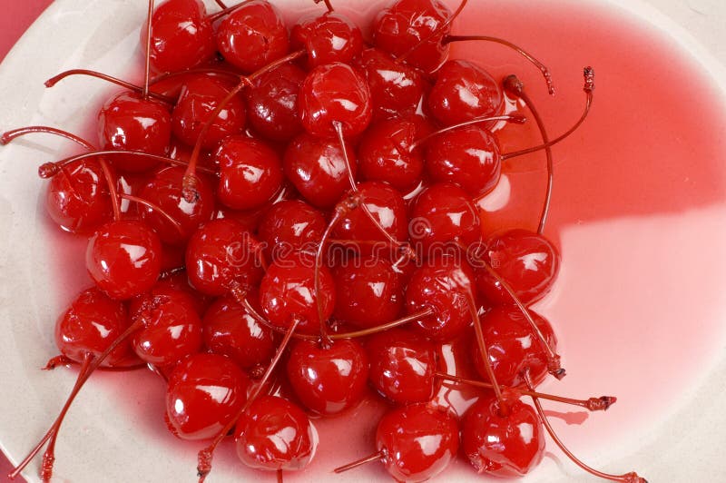 Red cocktail maraschino cherries on plate close up