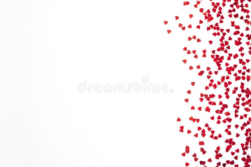 Red confetti in the form of hearts isolated on white background. Valentines day backdrop.