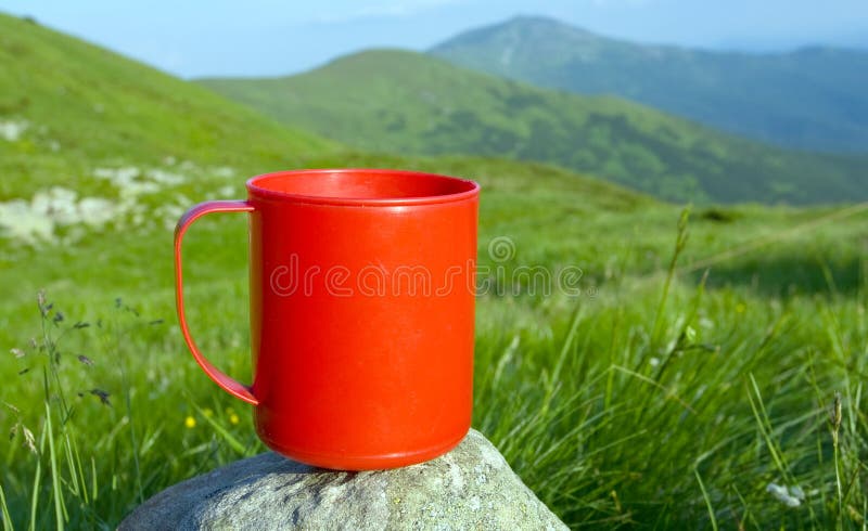 Red cup on stone in mountains camp