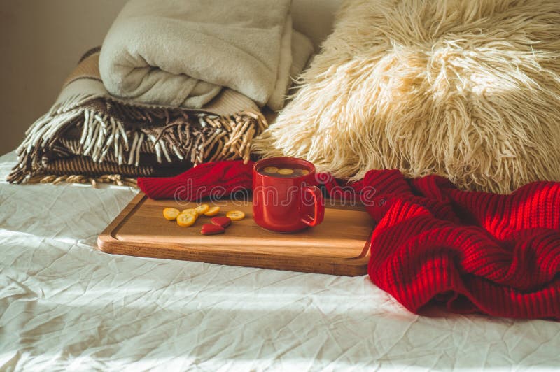 Red cup of tea with kumquat and two hearts cookies on a white bed. Cozy Home. Valentines day concept royalty free stock image Red cup of tea with kumquat and two hearts cookies on a white bed. Cozy Home. Valentines day concept royalty free stock image