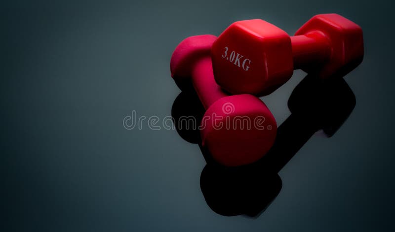 Red and dark pink dumbbells isolated on black background. 2, 3 kg dumbbells. Weight training equipment. Bodybuilding workout stock photo Red and dark pink dumbbells isolated on black background. 2, 3 kg dumbbells. Weight training equipment. Bodybuilding workout stock photo