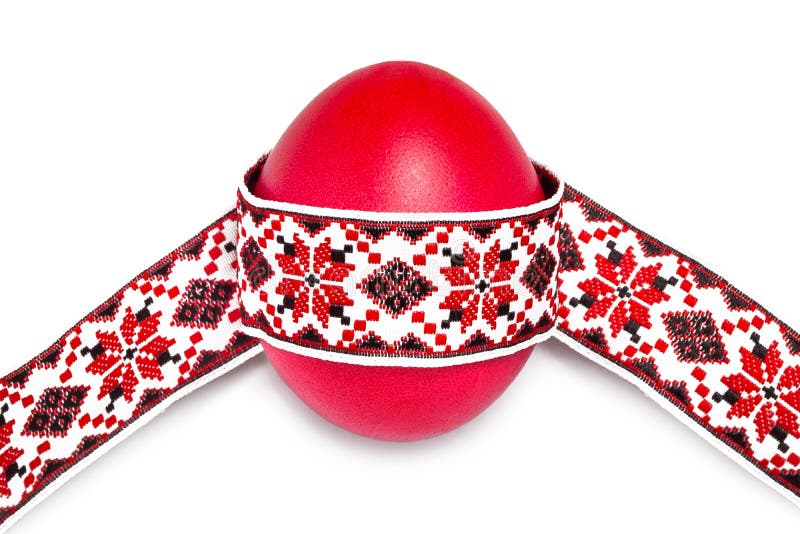 Red egg with national traditional ribbon on a white royalty free stock photos