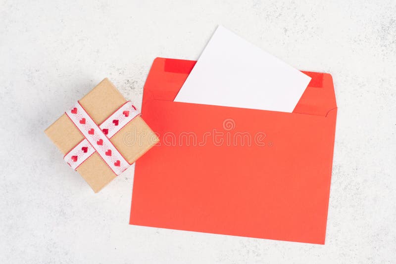 Red envelope with an empty paper, gift box with hearts, textured background, birthday, mothers day, fathers day and valintines day royalty free stock photos