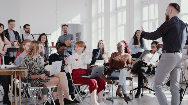 RED EPIC Feliz empresário de treinador de meia-idade lidera a discussão de seminário no escritório moderno para equipes multiétni