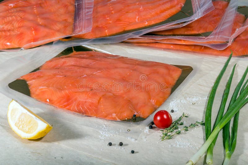 Red Fish in a Sealed Vacuum Plastic Bag on the Background of a Stack of