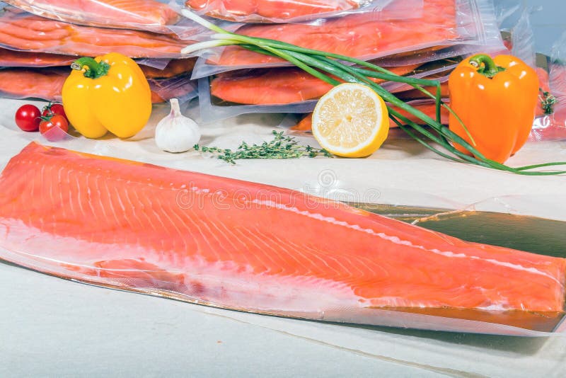 Red Fish in a Sealed Vacuum Plastic Bag on the Background of a Stack of