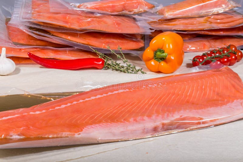 Red Fish in a Sealed Vacuum Plastic Bag on the Background of a Stack of