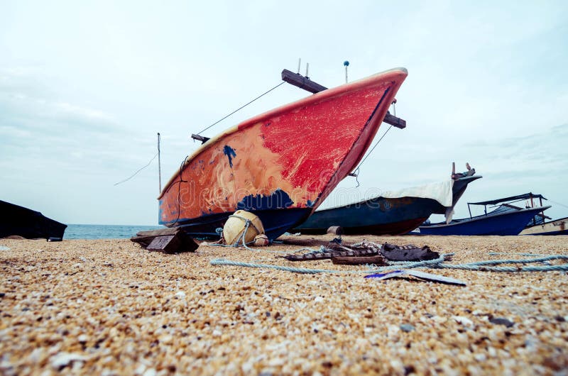 Red fisherman fiber boat on the sandy beach with white cloudy sky. royalty free stock images Red fisherman fiber boat on the sandy beach with white cloudy sky. royalty free stock images