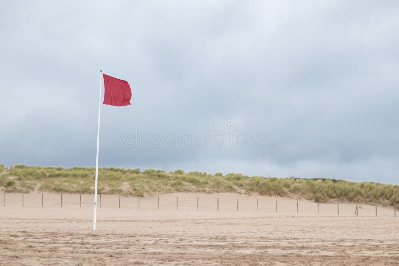 A red flag along the Dutch coast indicating it`s forbidden to swim in the ocean Kijkduin, The Hague, The Netherlands