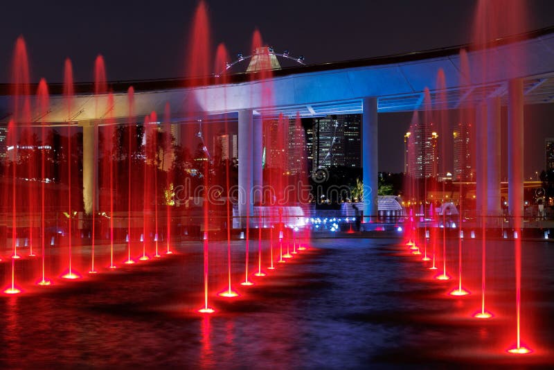 Rosso-fontane illuminate a Marina di Sbarramento, Singapore.