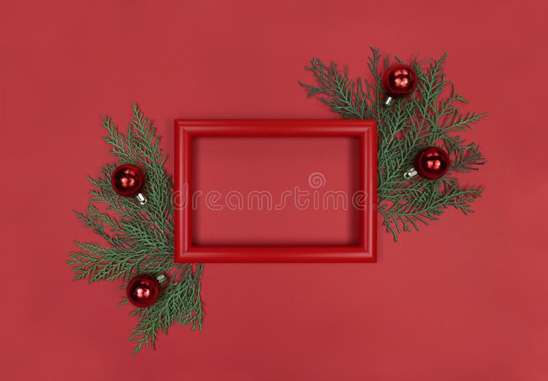 Red frame, tree branches and decor baubles. Christmas monochrome flat lay with copy space. stock photography