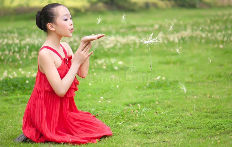 The red girl blowing dandelion