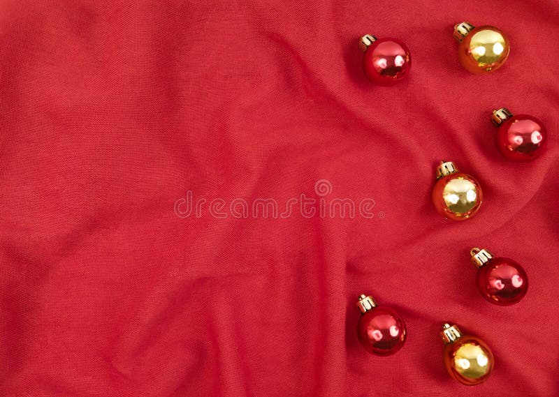 Red and gold Christmas balls on a red textile background royalty free stock image