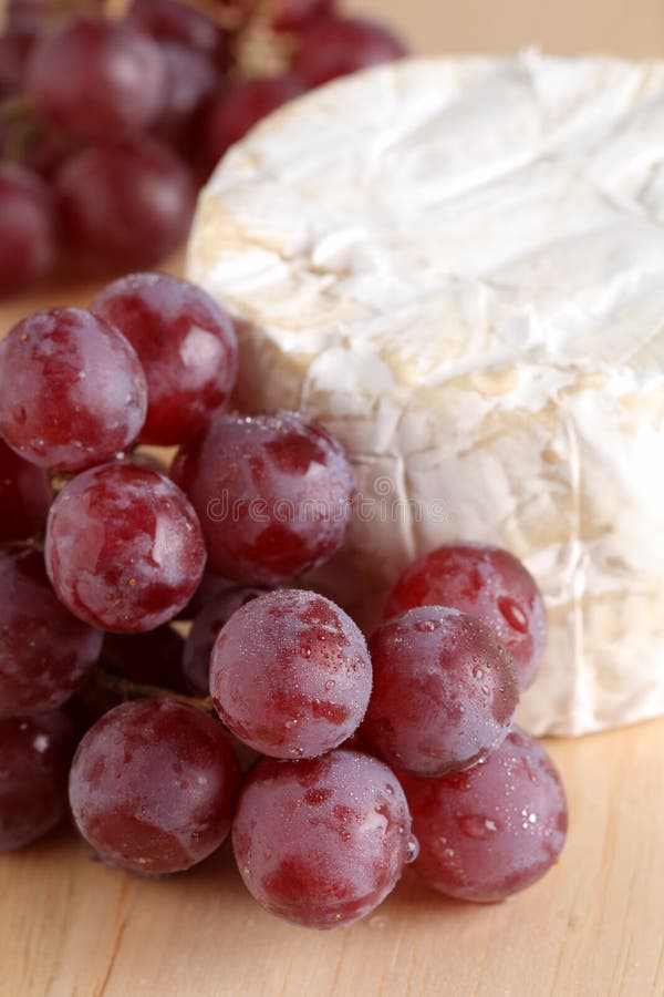 Red grape and soft cheese on wood