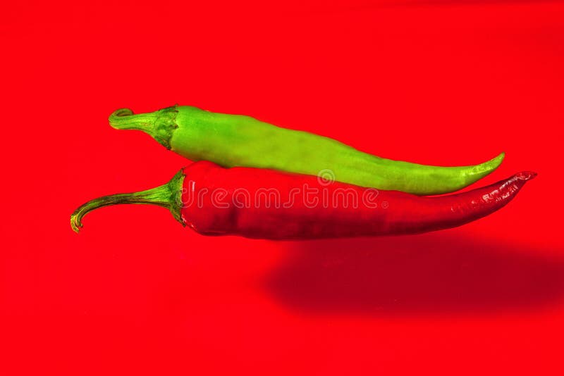 Red and green hot pepper on a red background