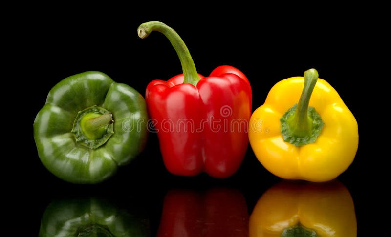 Red,green,yellow bell peppers isolated on black