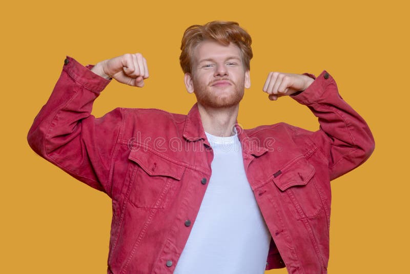 Redhaired Bearded Young Man in Red Jacket Showing Muscles Stock Image