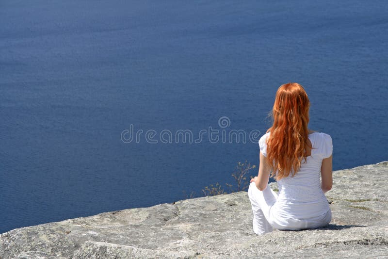 Red-haired Mädchen, das über blauem Wasser schaut lizenzfreies stockbild Red-haired Mädchen, das über blauem Wasser schaut lizenzfreies stockbild