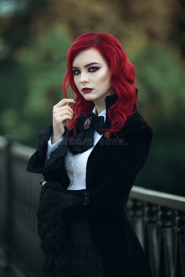 Red haired vampire girl in an old Museum in Gothic black clothes and a tailcoat