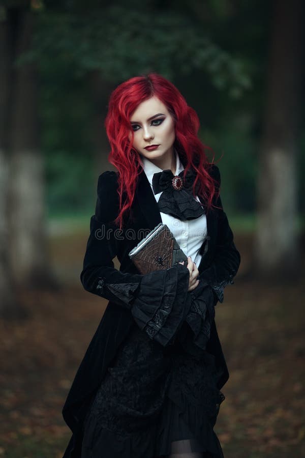 Red haired vampire girl in an old Museum in Gothic black clothes and a tailcoat dark book spider