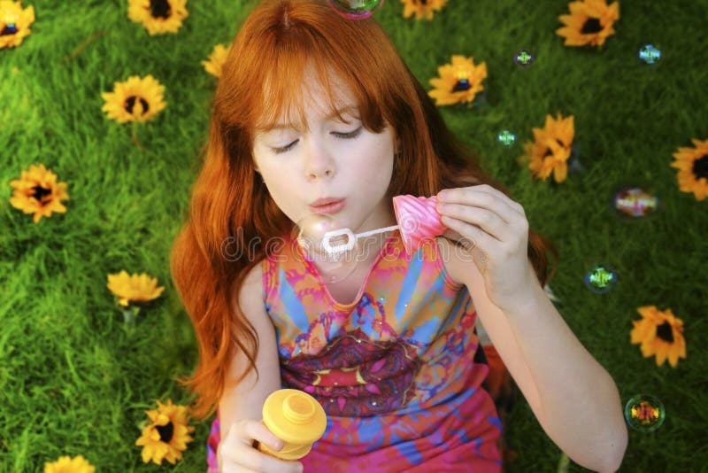 Red headed girl blowing bubbles