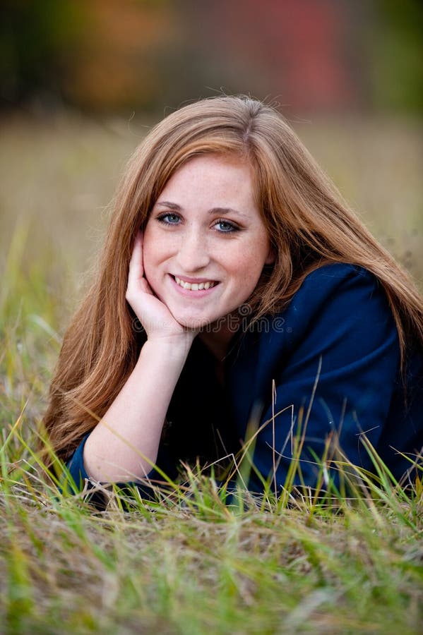 Red-headed teen girl lying in grass