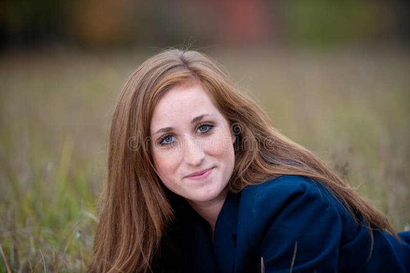 Red-headed teen girl lying in grass