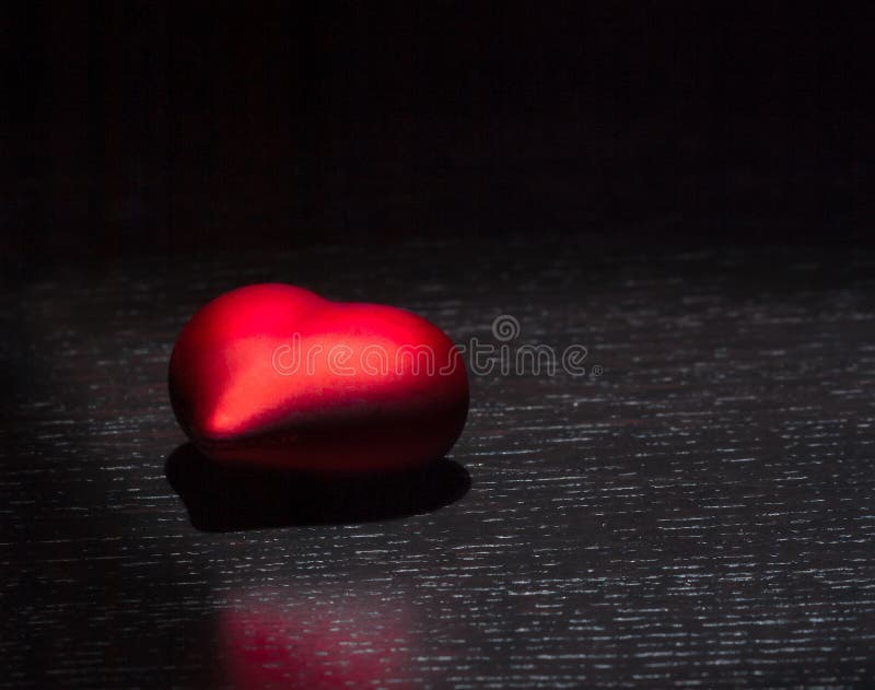 Red heart on black wood table, concept of valentine day