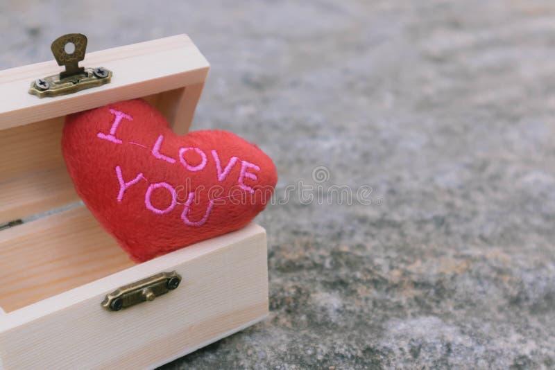 Red heart `I love you` in wooden treasure box with blur background. Simple and minimal retro style. Copy space for text, message, stock photography Red heart `I love you` in wooden treasure box with blur background. Simple and minimal retro style. Copy space for text, message, stock photography