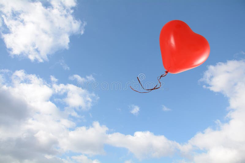 Red heart shaped balloon flies into the blue sky with clouds, love concept, copy space royalty free stock photo Red heart shaped balloon flies into the blue sky with clouds, love concept, copy space royalty free stock photo