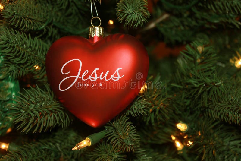 Red heart shaped Jesus Christmas ornament on tree