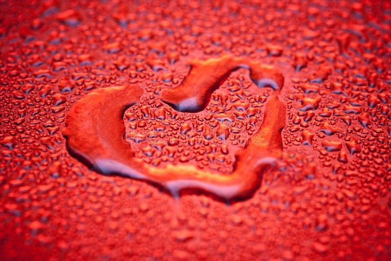 Red heart in water drops