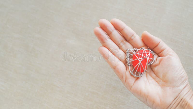Red Heart in Wire Mesh on Human`s Hand with Blurred Light Brown Background  Stock Photo - Image of faith, concept: 217050606